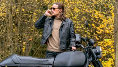 The man wearing biker leather jacket on phone.